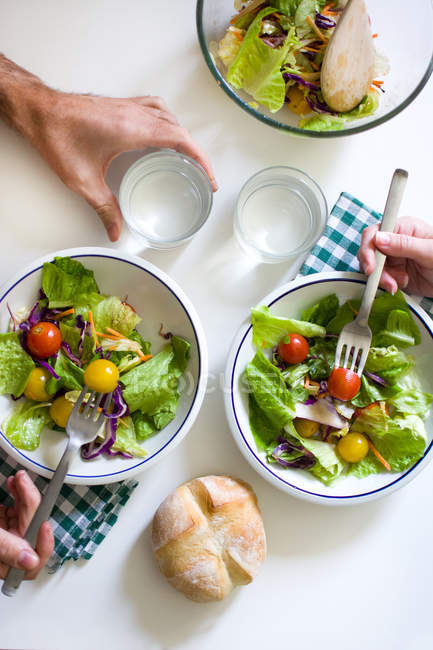 From above hands having fresh salad — Stock Photo