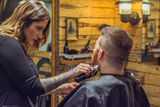 Femme coupe de cheveux un homme — Photo de stock