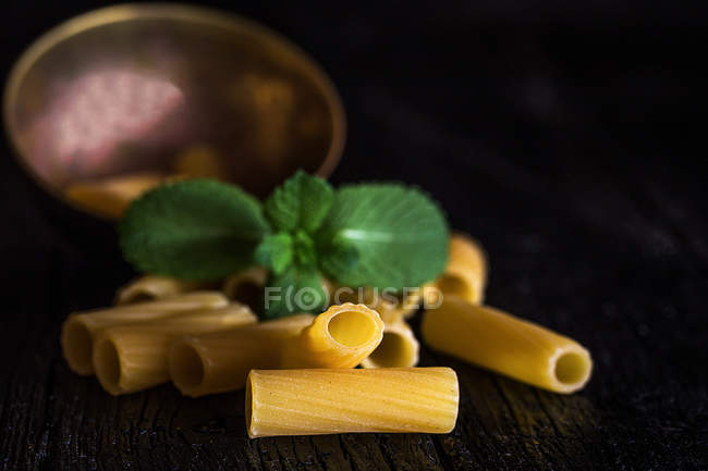 Uncooked pasta with mint leaves — Stock Photo