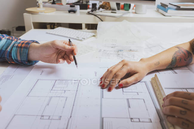 Vista lateral de mãos masculinas e femininas trabalhando em um esboço de projeto — Fotografia de Stock