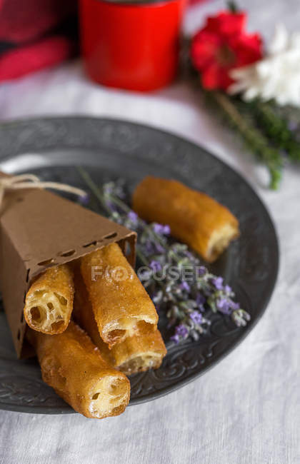 Plate with churros and lavender flowers — Stock Photo