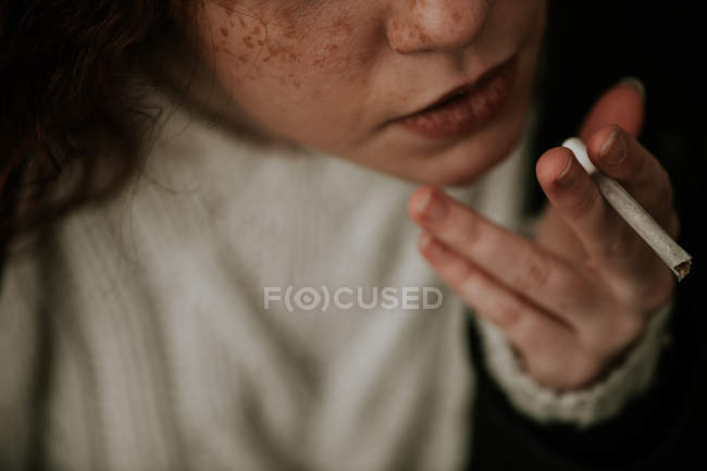 Курильщица с веснушками курит сигарету — стоковое фото