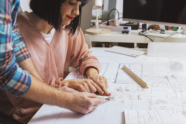 Side view of architects discussing blueprints in the office — Stock Photo