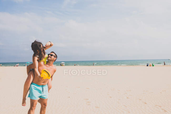 Счастливая пара веселится на солнечном пляже против морского пейзажа. Copyspace. — стоковое фото