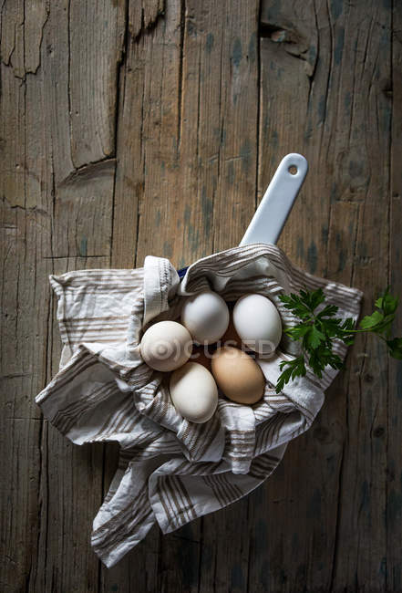 Безпосередньо вище подання курячі яйця в каструлі на дерев'яні таблиці — стокове фото