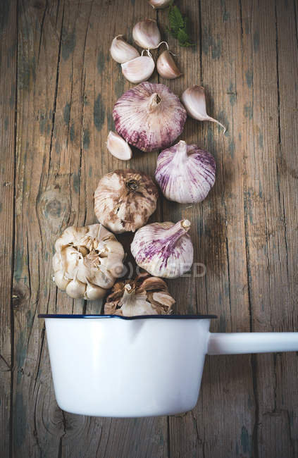 Arrangement of fresh garlic and scoop on wooden table — Stock Photo