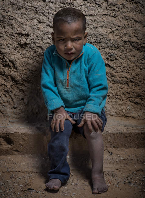Arabischer Junge sitzt und schaut in die Kamera — Stockfoto