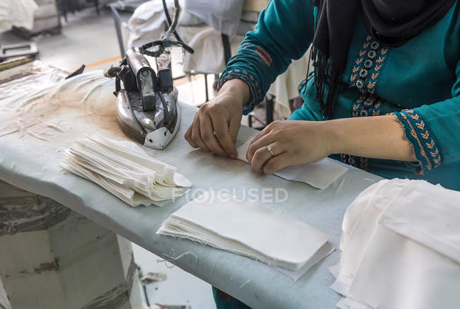 Середня секція працівника, що працює на фабриці одягу — стокове фото
