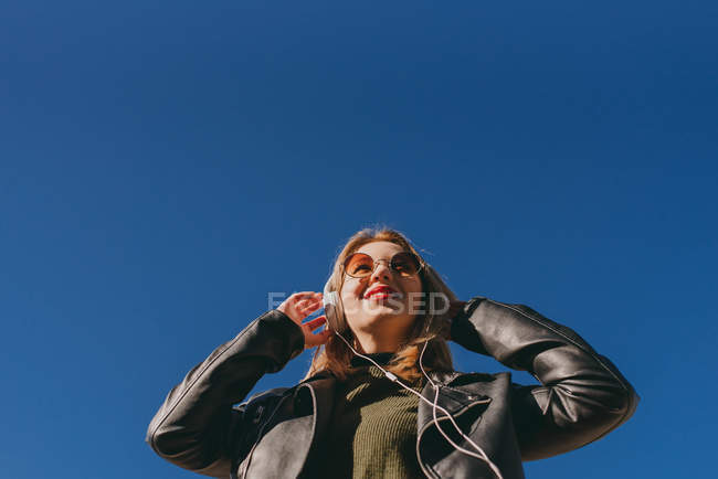 Chica con labios rojos ajuste de auriculares - foto de stock