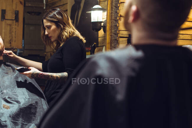 Mujer corte de pelo a un hombre - foto de stock