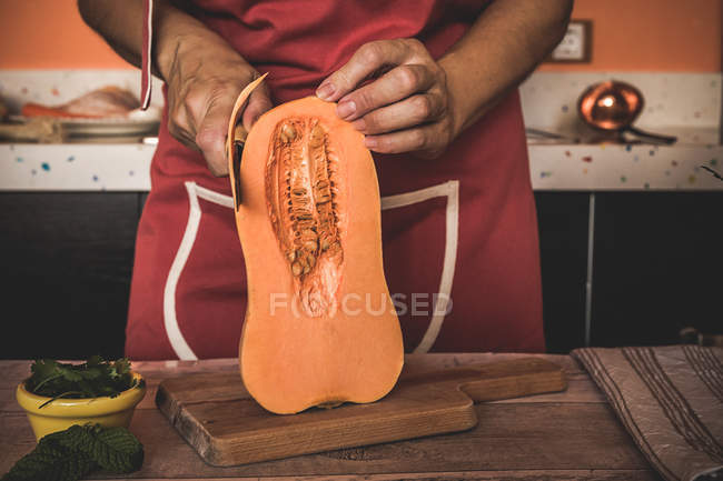 Розрив жіночого пілінгу гарбуза на дерев'яній дошці — стокове фото