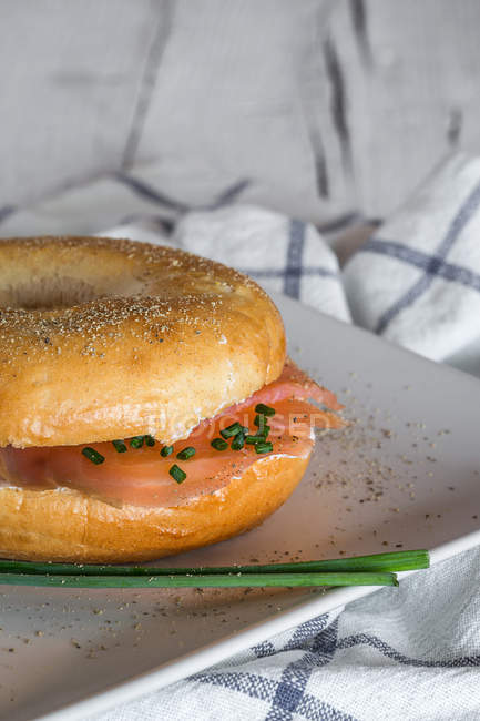Cultive delicioso bagel com salmão e queijo no prato — Fotografia de Stock