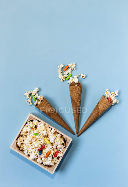 Palomitas de maíz con caramelos en caja y conos — Stock Photo