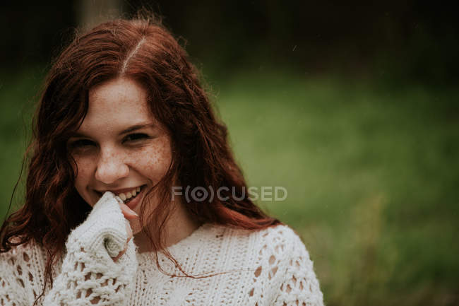 Симпатичная рыжая девушка смотрит в камеру и улыбается — стоковое фото