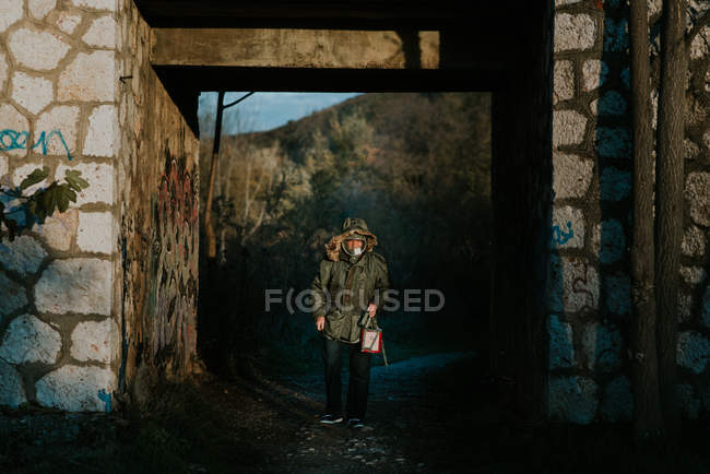 Portrait of man wearing gas mask standing in abandoned building arch — Stock Photo