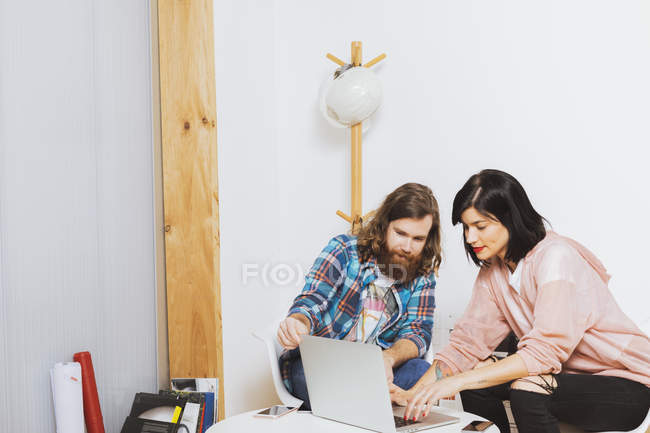 Homme et femme utilisant un ordinateur portable — Photo de stock