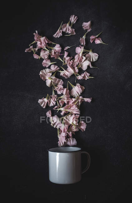 Top view of metal mug and blooms lying on stone surface — Stock Photo