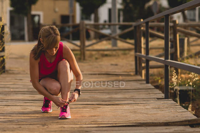 Sportwoman tying shoelaces — Stock Photo