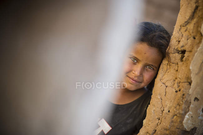 Araberin blickt durch Ruinen in die Kamera — Stockfoto