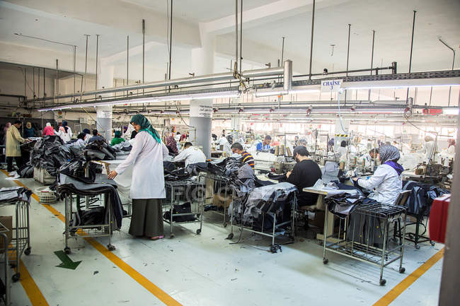 Tánger, MARRUECO- 18 de abril de 2016: Máquinas de coser industriales y trabajadores - foto de stock
