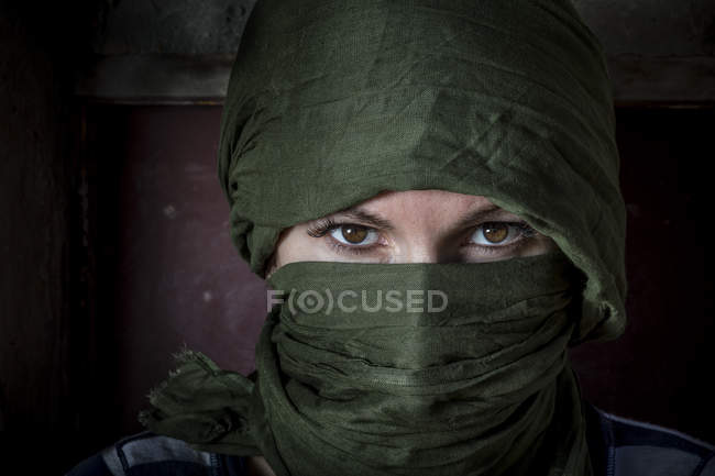 Женщина в зелёном хиджабе смотрит в камеру — стоковое фото