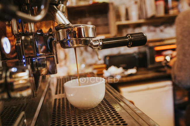 Close up view of coffee machine pouring coffee in white cup — Stock Photo