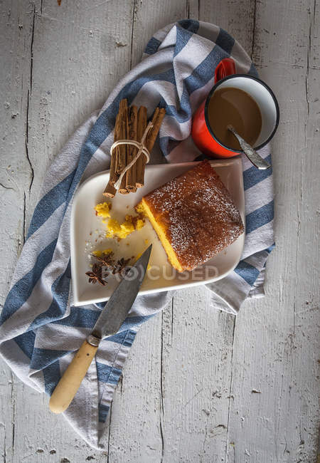 Над видом на ломтики лимонного торта на тарелке и кружку горячего шоколада — стоковое фото