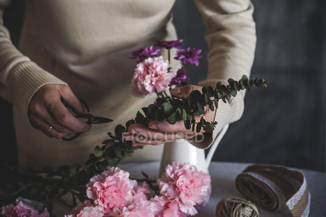 Mittelteil der Floristin macht Blumenstrauß auf Tisch — Stockfoto