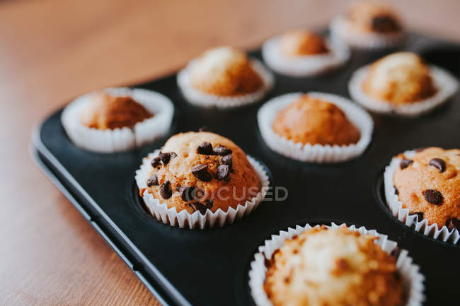 Vista de perto de muffins caseiros com chocolate na lata do padeiro — Fotografia de Stock