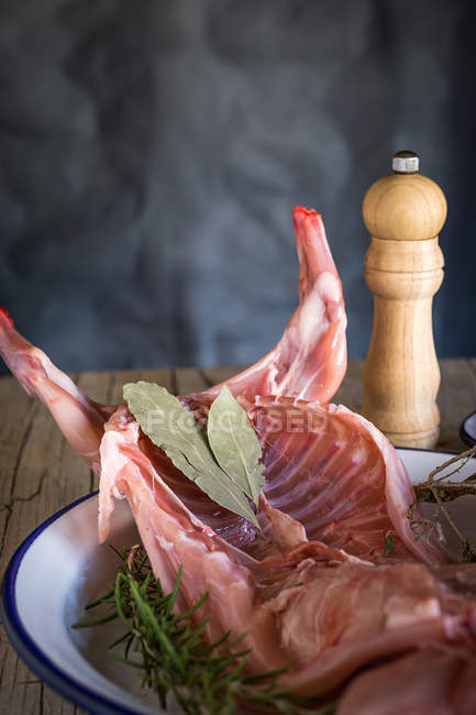 Carcasse de lapin cru avec des ingrédients sur une table en bois — Photo de stock