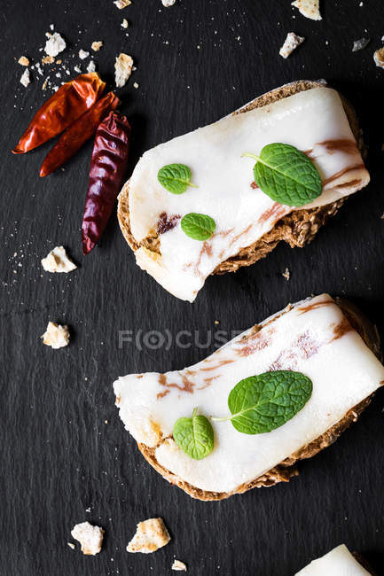 Sanduíches com bacon salobra e folhas de hortelã na ardósia — Fotografia de Stock