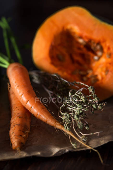 Close-up of fresh picked carrots with dried herb and pumpkin — Stock Photo
