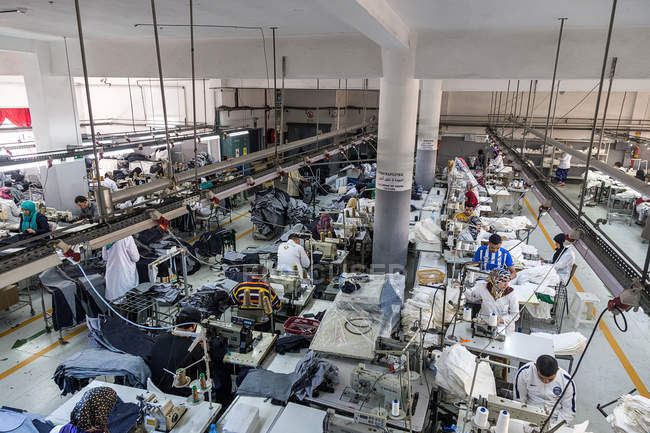 Tánger, MARRUECO- 18 de abril de 2016: Vista de ángulo alto a la sala de máquinas de coser industriales - foto de stock