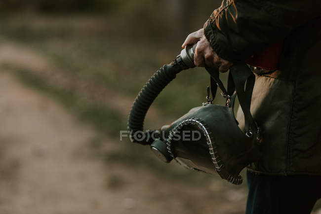 Обрізане зображення чоловічої руки, що тримає газову маску — стокове фото