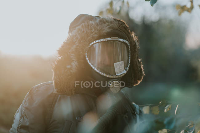 Porträt eines Mannes mit Gasmaske im Gesicht, der auf einem Feld steht — Stockfoto