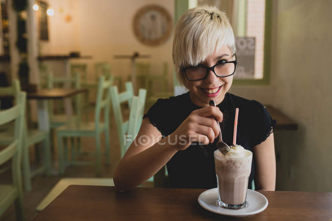 Дівчина в окулярах п'є молоко трясе — стокове фото
