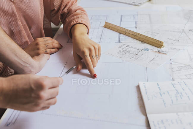 Female hands pointing with finger on blueprints — Stock Photo