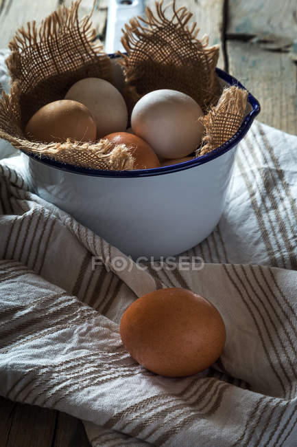 Uova in ciotola di metallo sul tavolo rurale — Foto stock