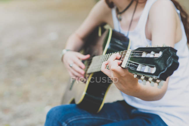 Metà sezione vista di ragazza che suona la chitarra in campagna scena — Foto stock