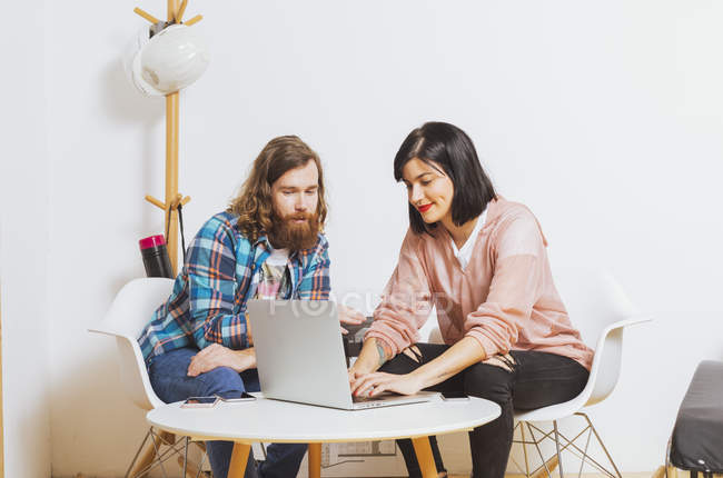 Homme et femme utilisant un ordinateur portable — Photo de stock