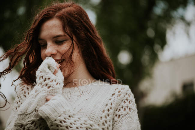 Рыжая девушка в белом свитере с низким углом — стоковое фото