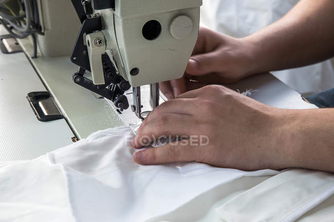 Обтинання чоловічої руки за допомогою швейні машини — стокове фото