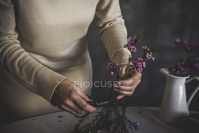 Середина жіночого флориста, що формує квітку для букета — стокове фото
