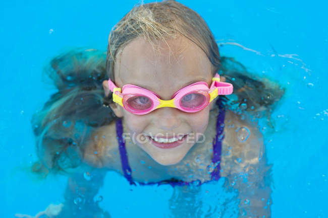 Дитина в окуляри в плавання в басейні і, дивлячись на камеру — стокове фото