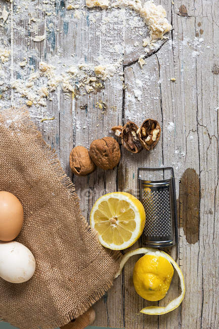 Top view of bakery ingredients and grater on rustic wooden table — Stock Photo