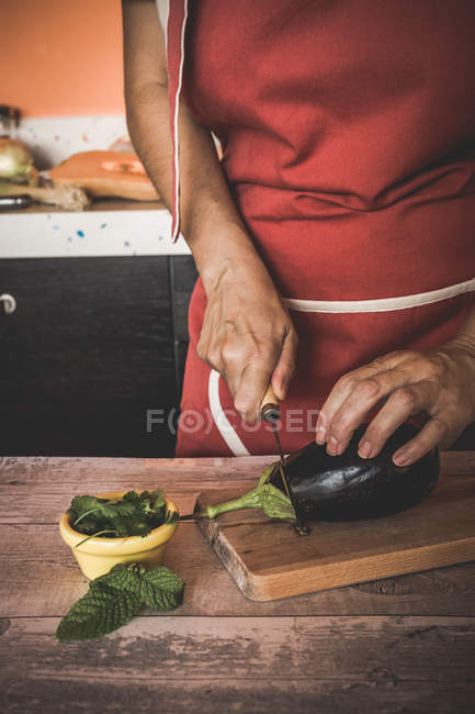 Crop woman slicing eggplant  on cutting board — Stock Photo