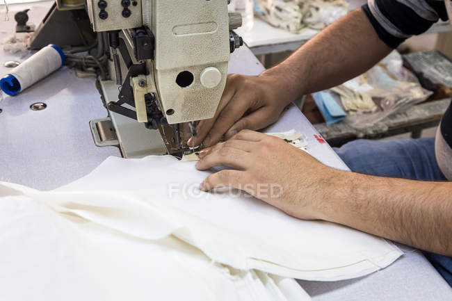 Mãos de lavrador usando máquina de costura — Fotografia de Stock