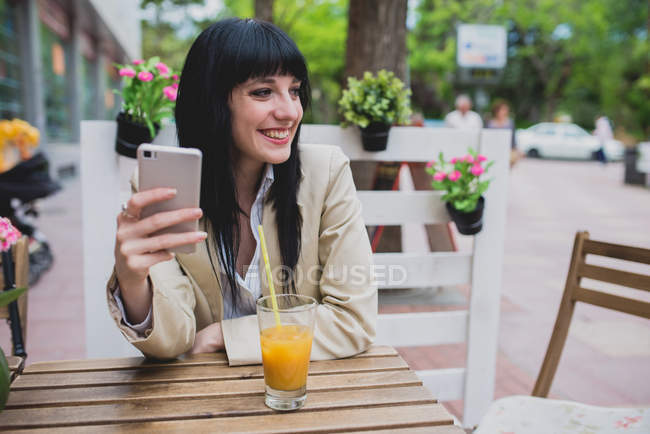 Brunette woman holding smartphone — Stock Photo