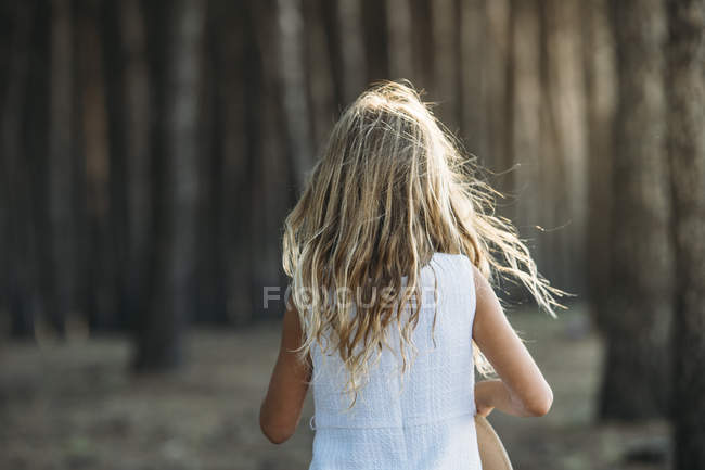 Вид ззаду дитини на сонячне світло на тлі лісу . — стокове фото