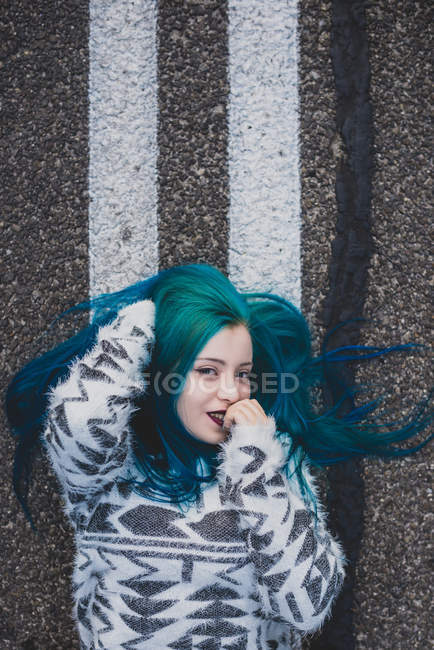 Girl lying on road and flirtatious looking at camera — Stock Photo